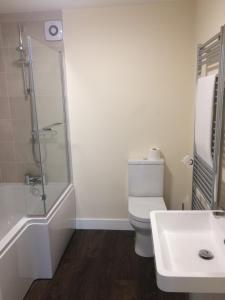 a bathroom with a toilet and a shower and a sink at Hilltop Cottage in Dursley