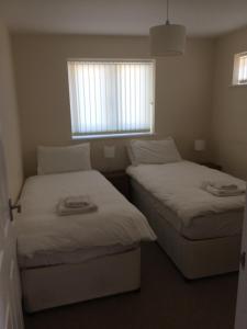 2 camas en una habitación pequeña con ventana en Hilltop Cottage en Dursley