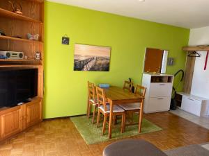 a kitchen with a table and a green wall at CASA PONTE: Gordola in Gordola