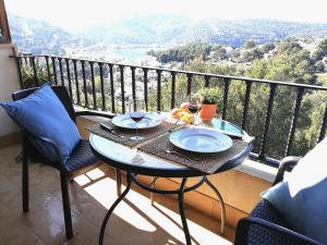 una mesa con 2 platos de comida en el balcón en Alojamiento Ponent - Apartaments tres Vents, en Sóller