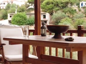 a wooden table with a bowl on a balcony at Villa Melini in Patitiri