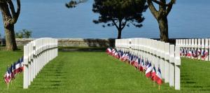 a white fence with american flags in the grass at Villa kahlo Omaha Beach in Colleville-sur-Mer