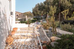 a garden with a stone walkway next to a house at SeaView Apartment & Studio in Psili Ammos