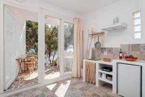 a kitchen with a sliding glass door to a patio at SeaView Apartment & Studio in Psilí Ámmos