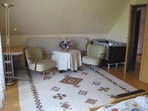 a living room with a table and two chairs and a rug at Ferienwohnung-Zur-Loewengrube in Brietlingen
