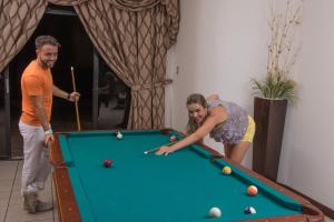 een man en een vrouw die een spelletje pool spelen bij Resort y Parque Acuatico Valle Dorado in El Rosario