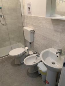 La salle de bains est pourvue de toilettes, d'un lavabo et d'une douche. dans l'établissement Le stanze della Lanterna, à Gênes