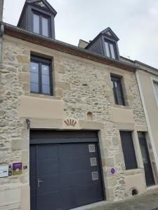 uma porta de garagem em frente a um edifício de pedra em CHARMES EN VILLE Le Charme Poétique em Montluçon