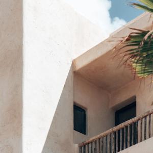 a white building with two windows and a balcony at Casa Pacha Formentera in Playa Migjorn