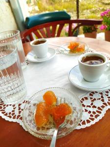 a table with a plate of oranges and a cup of coffee at Ancient Gortyna Home -Basilica & Mosaic View in Mitrópolis