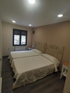 - une chambre avec 2 lits et une fenêtre dans l'établissement Casa rural pepe, à Frías