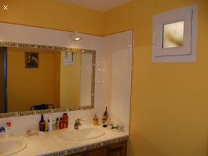 a bathroom with two sinks and a large mirror at Perle rare in Sainte-Croix-de-Verdon