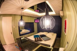 um pequeno quarto com uma cama e duas luzes pendentes em Motel Paradiso - Tapera em Tapera