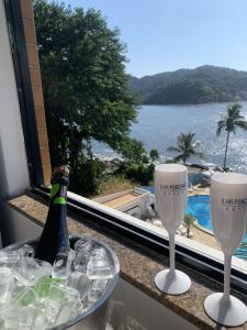 a table with wine glasses and a view of the ocean at Ilha Porchat Hotel in São Vicente