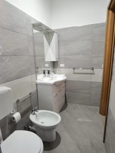 a bathroom with a white toilet and a sink at appartamento dei colori anticaglie in Punta Secca