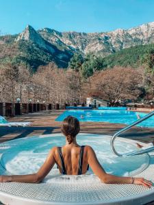 una mujer sentada en un jacuzzi en una piscina en Eco Hotel Polyana Skazok, en Yalta