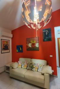 a living room with a couch and a chandelier at appartamento dei colori anticaglie in Punta Secca