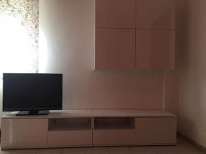 a television sitting on top of a cabinet in a room at appartamento dei colori anticaglie in Punta Secca