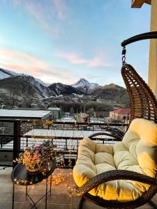 a couch sitting on a balcony with a view of mountains at Belmonte Kazbegi in Kazbegi