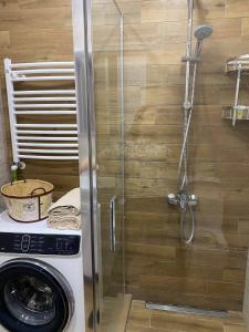 a shower in a bathroom with a washing machine at Sol's M2 White Modern Apartments in Tbilisi City +105 photos