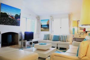 a living room with white furniture and a fireplace at Fantástica Casa com 4 Quartos na Praínha in Alvor