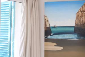 a room with a window and a painting of the ocean at Fantástica Casa com 4 Quartos na Praínha in Alvor