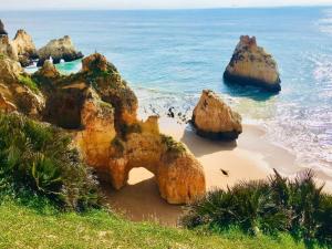 a group of rocks on a beach next to the ocean at Fantástica Casa com 4 Quartos na Praínha in Alvor