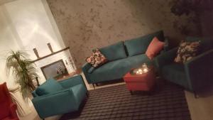 a living room with a green couch and two chairs at Apartament Margaret Twardogóra in Twardogóra