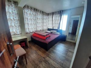 Un dormitorio con una cama con una maleta roja. en SASHI HOME a Cupid Destination en Darjeeling