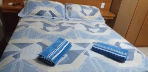Una cama con almohadas azules encima. en Cobertura Climatizada, Spa no litoral, en Cabo Frío