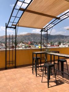 a patio with tables and chairs and a view of a city at Hostal Andaina in Oaxaca City