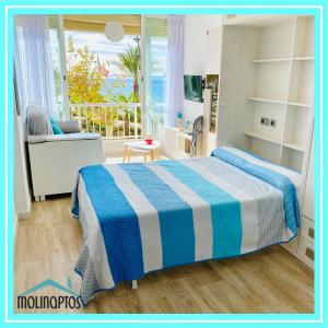 a bedroom with a blue and white bed and a window at Estudio 32 Frente al Mar by Molinaptos in Benidorm