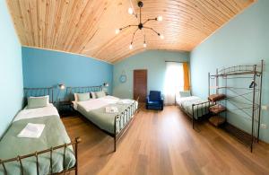 a bedroom with two beds and a wooden ceiling at Belmonte Kazbegi in Kazbegi