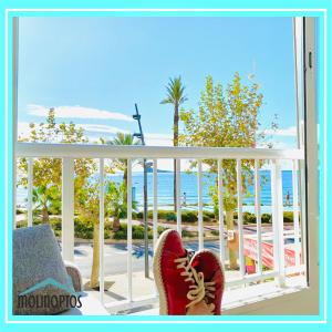 a pair of red shoes sitting on a porch looking at the ocean at Estudio 32 Frente al Mar by Molinaptos in Benidorm