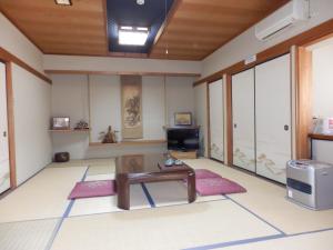 a living room with a table and a tv at Minshuku Ginmatsu in Kanazawa