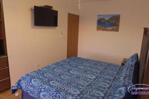 a bedroom with a blue bed with a tv on the wall at Departamento Topacio 1 Joyas del Mar in San Carlos +28 photos