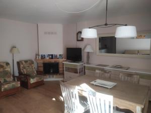 a living room with a table and chairs and a television at El Mirador de Ordesa in Torla-Ordesa