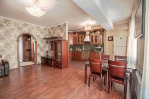 a kitchen with wooden floors and a table and chairs at Welcome Home Apartments Baikalskaya 107 in Irkutsk