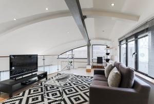 a living room with a couch and a tv at Monument by Excel Apartments in London