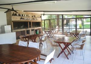 un restaurant avec des tables et des chaises en bois ainsi que des fenêtres dans l'établissement Windmuhle Apart Hotel & Spa, à Villa General Belgrano