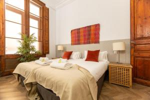 バルセロナにあるGreat Spacious Apartment in the Gothic District City Centerのベッドルームにタオル付きのベッド2台が備わります。