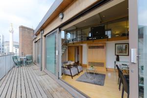 an apartment balcony with a living room and dining room at Monument by Excel Apartments in London