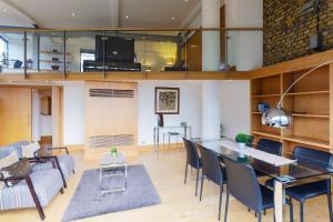 a living room with a table and chairs and a couch at Monument by Excel Apartments in London