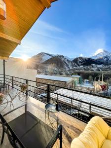 einen Balkon mit Blick auf die schneebedeckten Berge in der Unterkunft Belmonte Kazbegi in Kazbegi