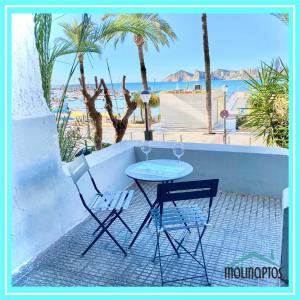 uma mesa e duas cadeiras com vista para a praia em Loft frente al Puerto by Molinaptos em Benidorm