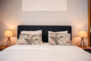 a bedroom with a large bed with two lamps at City Apartment Dorobantilor in Cluj-Napoca