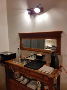 - un comptoir de cuisine avec un évier et un miroir dans l'établissement CHARMES EN VILLE Le Charme Atypique, à Montluçon