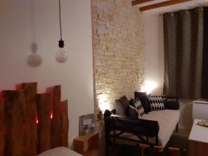 a living room with a couch and a brick wall at CHARMES EN VILLE Le Charme Atypique in Montluçon
