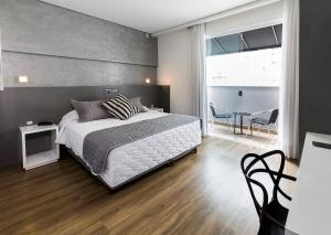 um quarto com uma cama, uma mesa e cadeiras em Tropikalya Gold Hotel em Balneário Camboriú
