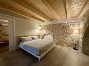 a bedroom with a bed and a stone wall at Albertario in Acquaviva delle Fonti
